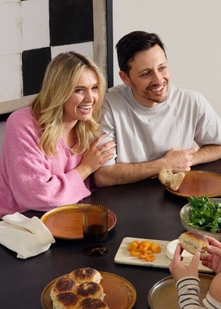 Couple smiling at a table looking at a tablet, representing a low deposit home buying journey with Homebuyers Centre and Resolve Finance